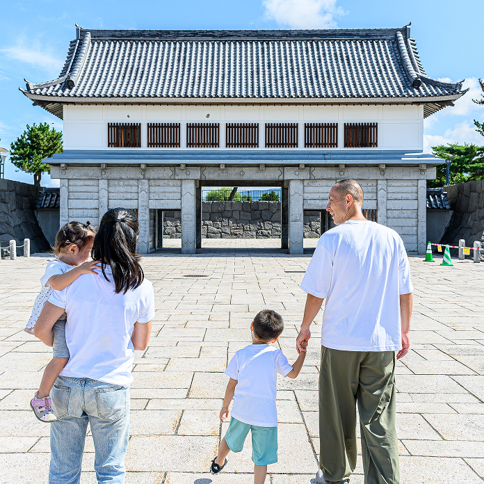 公園の入り口に向かう親子連れの後ろ姿
