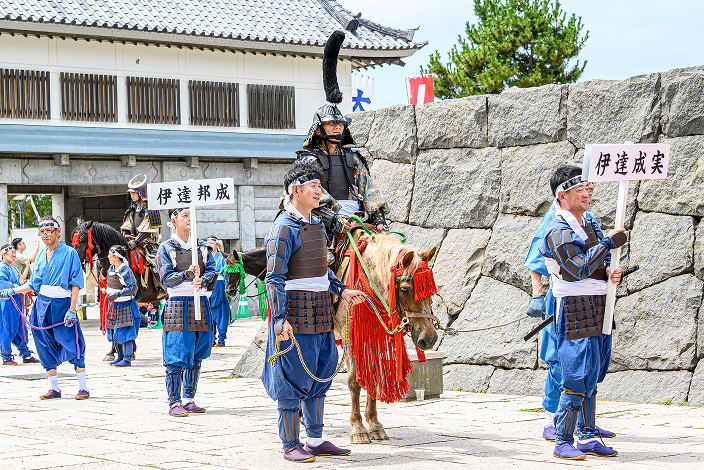 馬に乗った伊達成実と武者行列の様子