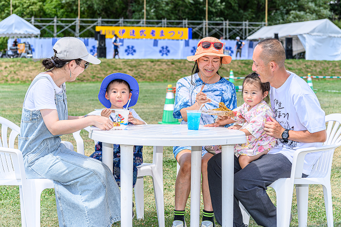 おまつり広場で食事を楽しむ親子連れ